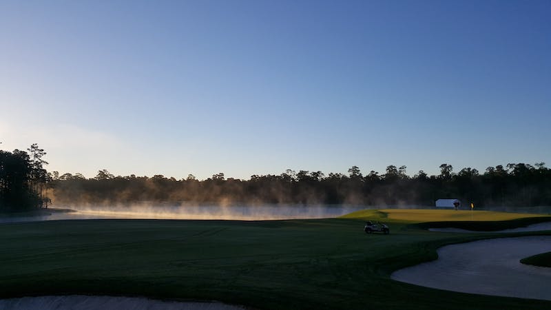 Mist rises up from a beautiful golf course in the morning.